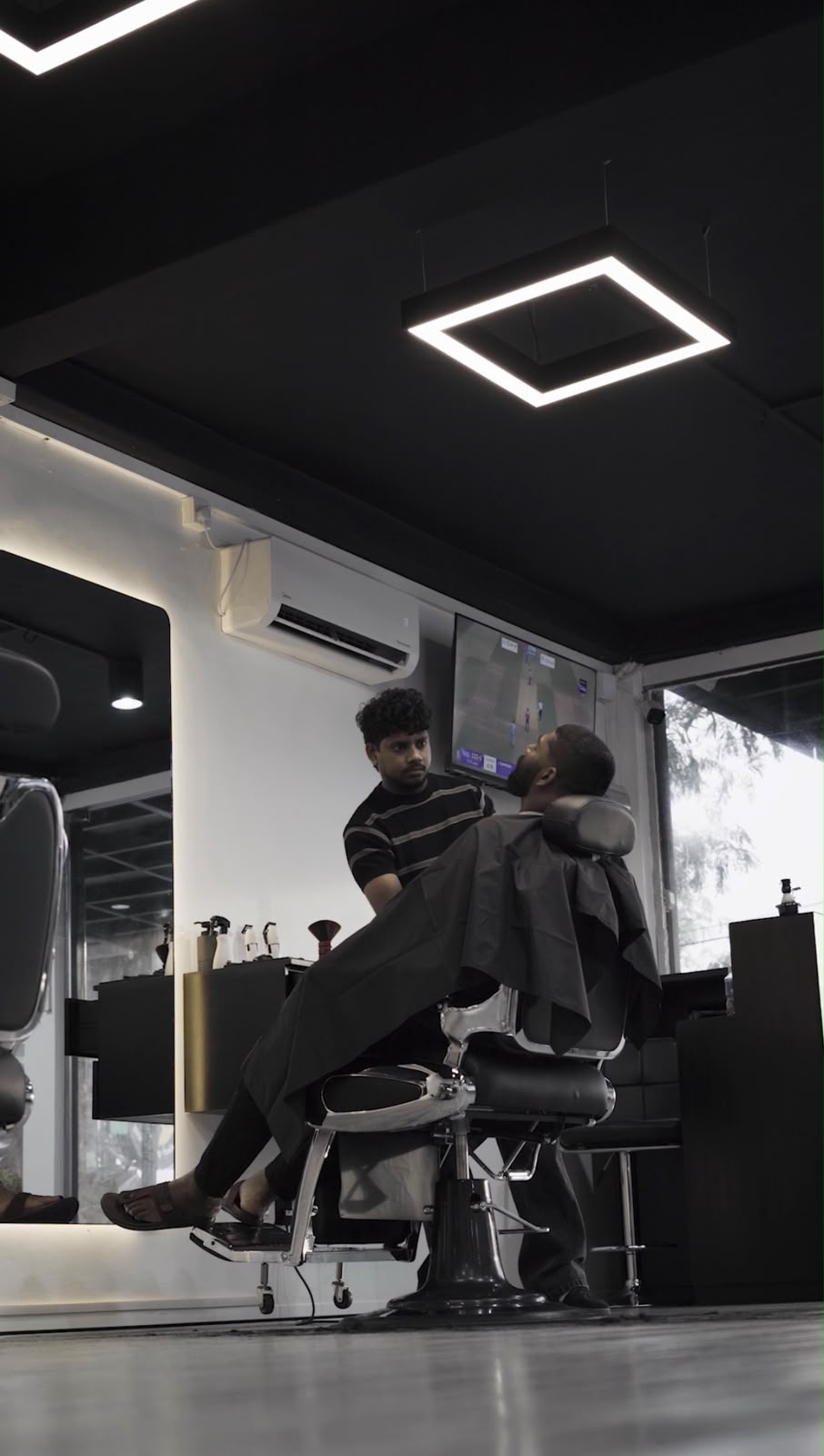 Barber styling a client in the Alpha Fades studio